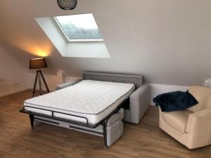 a bed and a couch in a room with a skylight at Appartement la trinité sur mer in La Trinité-sur-Mer