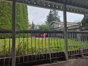 a fence in front of a yard with a house at Enjoy Life in Heart of North Delta in Delta