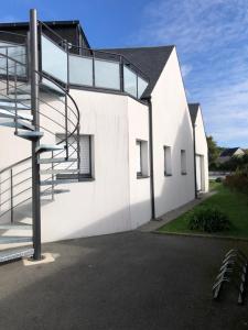 a white house with a spiral staircase on it at Appartement la trinité sur mer in La Trinité-sur-Mer