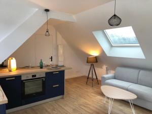 a kitchen and living room with a couch and a window at Appartement la trinité sur mer in La Trinité-sur-Mer