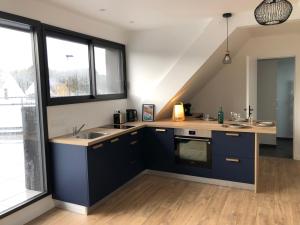 a kitchen with blue cabinets and a sink at Appartement la trinité sur mer in La Trinité-sur-Mer +8 photos