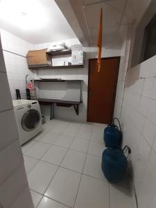 een kleine keuken met een wasmachine en een deur bij Circuito dos Trios! in Água Boa
