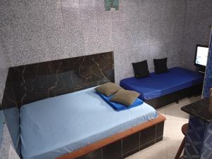 two beds in a room with blue sheets at CASAS e KITNETS NOSSO CANTINHO in Barra do Sahy