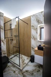 a bathroom with a shower with a marble wall at Fit Residence Hasdeu in Cluj-Napoca