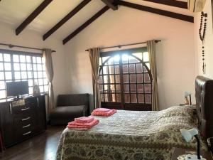 a bedroom with a bed and a chair and a television at La Casa de Don Lucho - Santa Cruz in Santa Cruz de la Sierra