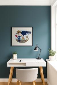 a white desk in a room with a blue wall at Green Brook - Blue Suite in Aalborg