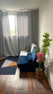 a bedroom with a blue couch in front of a window at Espaço do Adilson em Paciência RJ in Rio de Janeiro