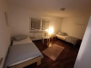 a small room with two beds and a window at FeWo Im Drosselnest in Hechingen