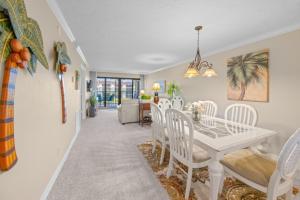 萨尼贝尔Pointe Santo B32 condo的餐厅和客厅配有白色桌椅