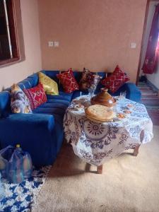 a blue couch with a table in a living room at Dar Agourzi Café des Epices in Tacheddirt +5 photos