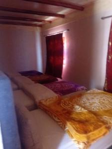 a bedroom with two beds and a window at Dar Agourzi Café des Epices in Tacheddirt