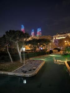 a swimming pool at night with the city lights at Caspian Hostel in Baku