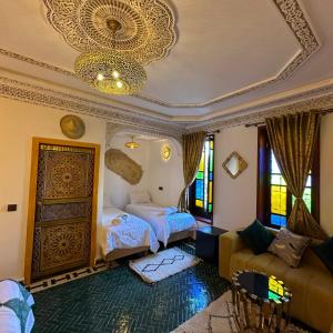 een woonkamer met twee bedden en een bank bij Riad Dar El bellar in Fès +57 foto's