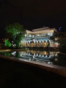 a building at night with a pond in front of it at Caspian Hostel in Baku