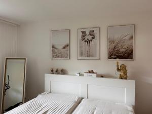 1 dormitorio con 1 cama blanca y 4 cuadros en la pared en Pudelwohl in Obermelsungen, en Melsungen