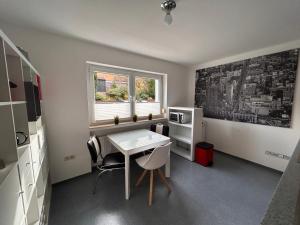 Habitación pequeña con mesa, sillas y ventana en Pudelwohl in Obermelsungen, en Melsungen