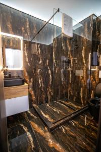 a bathroom with a glass shower and a sink at Fit Residence Hasdeu in Cluj-Napoca