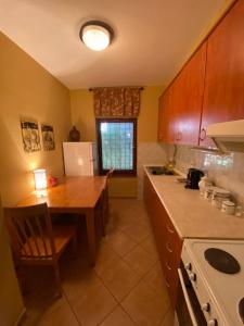 a kitchen with a wooden table and a kitchen with a refrigerator at Tito's Place in Ohrid
