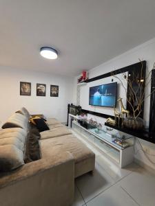 a living room with a couch and a flat screen tv at Apartamento Artzoo in Pomerode
