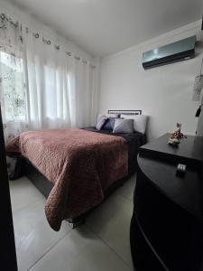 a bedroom with a bed and a dresser at Apartamento Artzoo in Pomerode