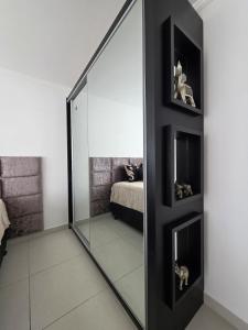 a large mirror in a room with a bedroom at Apartamento Artzoo in Pomerode +6 photos