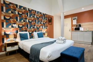 a bedroom with a large bed with blue pillows at NG Prestige - Nain - Suite Spa Privatif - Jacuzzi - Netflix - Projecteur in Roubaix +67 photos