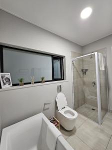 a white bathroom with a toilet and a shower at CostaBella in Gqeberha