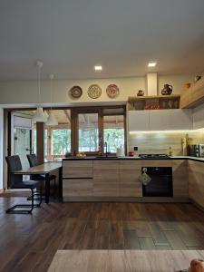 eine Küche mit Tisch und ein Esszimmer in der Unterkunft Sodyba jūsų poilsiui ant ežero kranto in Giedraičiai