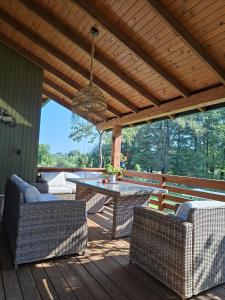 eine Terrasse mit Tisch und Stühlen auf einem Deck in der Unterkunft Sodyba jūsų poilsiui ant ežero kranto in Giedraičiai