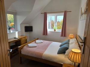 a bedroom with a bed and a window at Farthing Cottage in Norwich