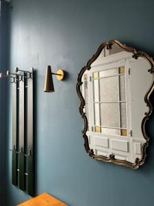 a mirror on a blue wall with a window at Apparemment de style 70s in Colmar