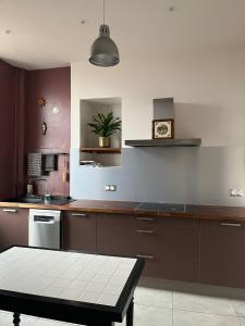 een keuken met bruine kasten en een tafel. bij Apparemment de style 70s in Colmar