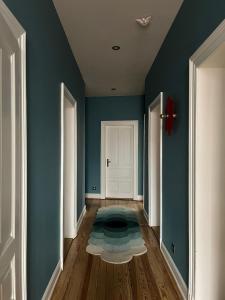 een hal met blauwe muren en een tapijt op de vloer bij Apparemment de style 70s in Colmar +9 foto's