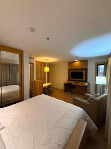 sypialnia z dużym łóżkiem i salonem w obiekcie Suíte Particular no Transamerica Executive Faria Lima w São Paulo