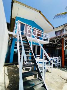 a staircase leading up to a house with tables and chairs at Why Not Guest house in Hikkaduwa