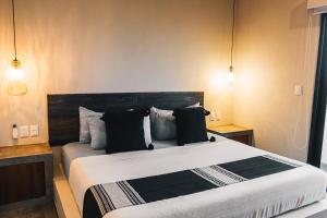 un dormitorio con una cama grande con almohadas blancas y negras en The Garden Suite, en El Rebalse 29 fotos más