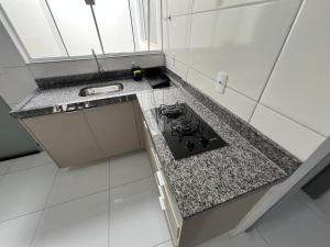 a kitchen with a stove and a counter top at Residencial jardim bougainville in Sinop