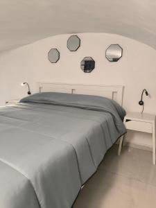 a white bedroom with a bed and a table at La Nica in Catania