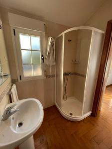 een witte badkamer met douche en wastafel bij Casa Os Batáns in Vimianzo +53 foto's