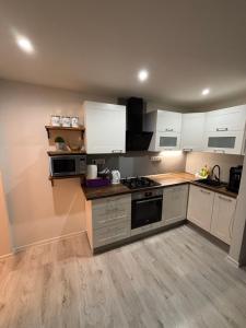 a kitchen with white cabinets and a stove top oven at Apartmánový byt VYHNE in Vyhne