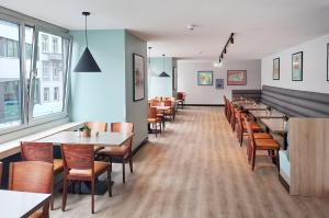 una fila de mesas y sillas en un restaurante en Garner Hotel Hamburg - Graf Moltke by IHG, en Hamburgo