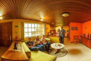 a group of people sitting on a couch in a living room at La Casa del Molino Blanco B&B in Baños