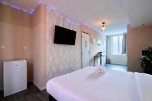 a room with a bed with a tv on a wall at NG Prestige - Lille I Roubaix Centre I Grande Rue - Studio - Netflix & Wifi in Roubaix