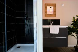a bathroom with a bath tub and a sink at NG Prestige - Lille I Roubaix Centre I Grande Rue - Studio - Netflix & Wifi in Roubaix +26 photos