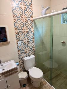 Un baño con inodoro y ducha de cristal. en Casa no centro de Urubici Dutra Borba, en Urubici 38 fotos más
