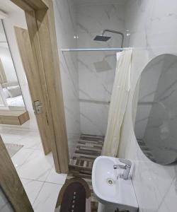 a bathroom with a sink and a shower with a mirror at Zendidisluxuryapartments in Lekki