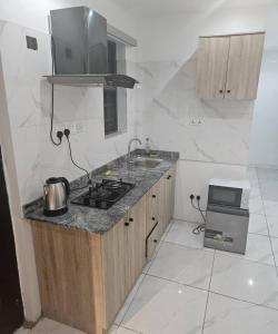 a kitchen with a stove and a sink in it at Zendidisluxuryapartments in Lekki