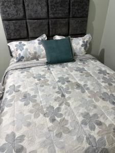 a bed with a gray and gray comforter and pillows at Carolus Suites in Gros Islet