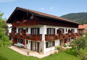 ein großes Gebäude mit Holzbalkonen darauf in der Unterkunft Gästehaus Maier zum Bitscher in Rottach-Egern