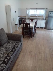 ein Wohnzimmer mit Couch und Tisch und eine Küche in der Unterkunft Serena del Mar in Nueva Atlantis